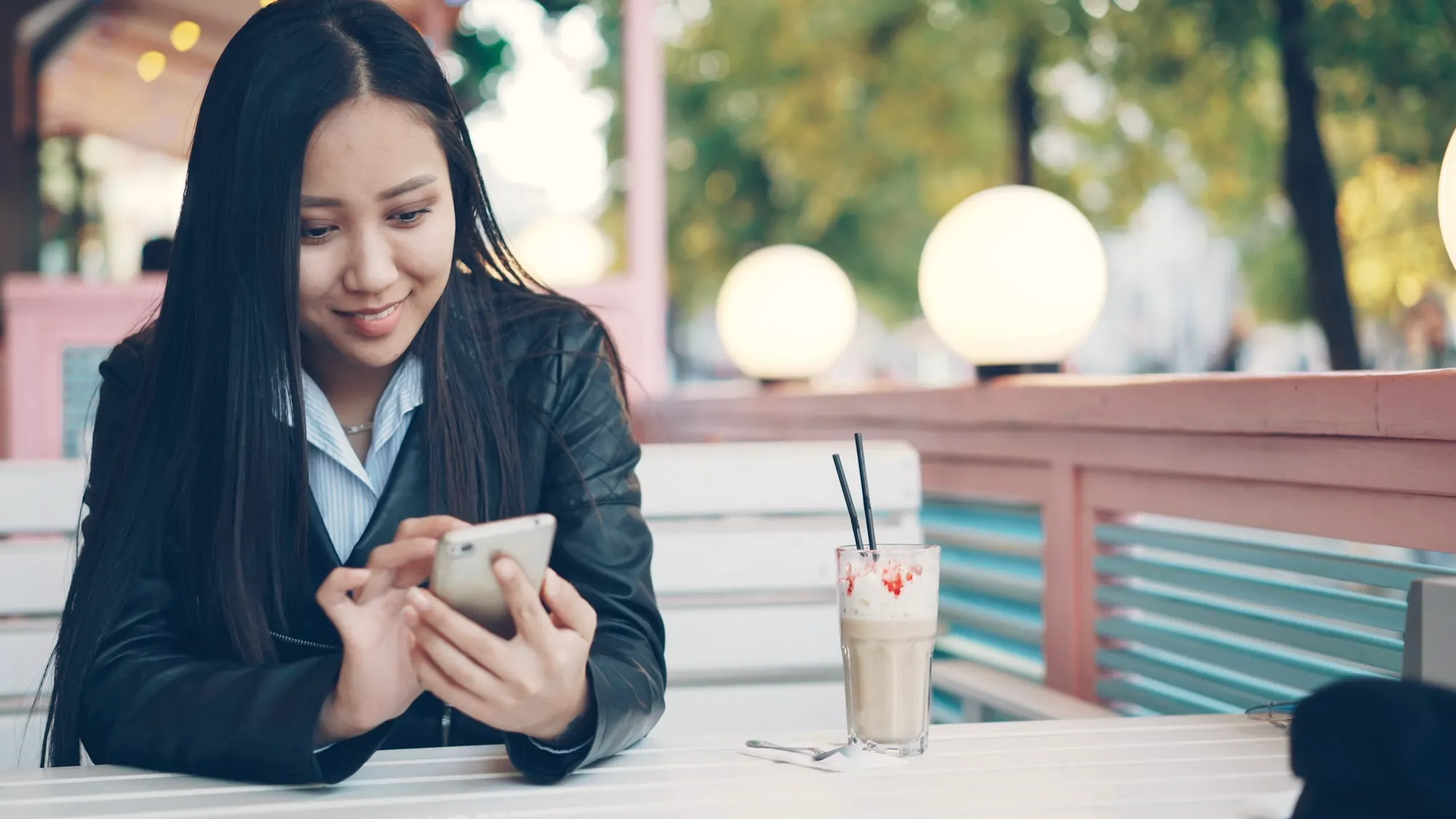 A woman checking a business on her phone at a cafe